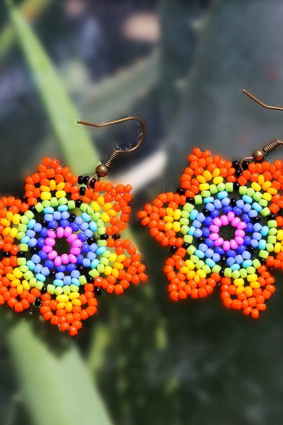 Arete multicolor, en forma de flor con pétalos puntiagudos. Tejido en cuentas usando técnica Huichol. Tiempo de elaboración de un día aproximadamente.