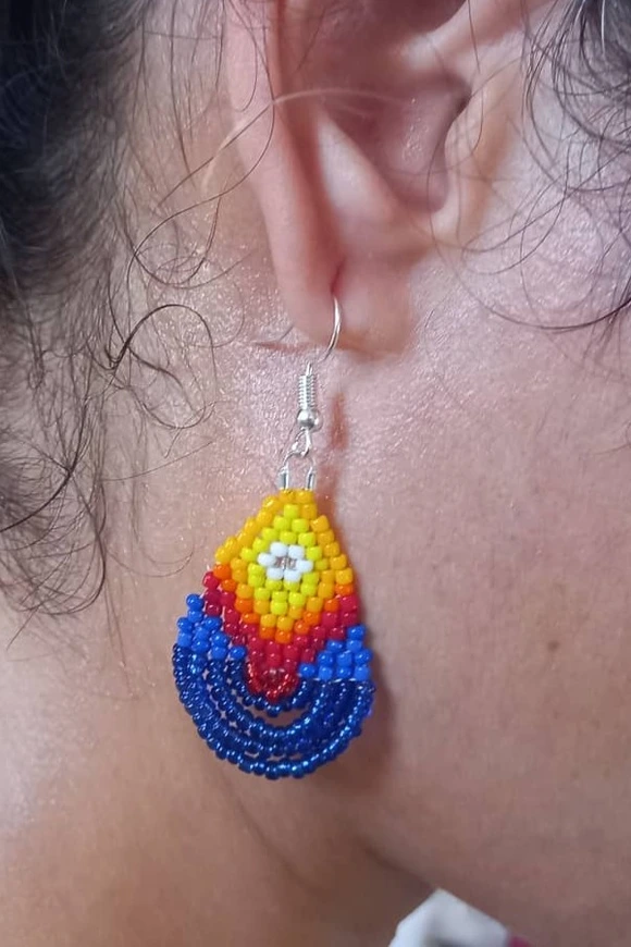 Aretes en forma de gotas de agua, colores que evocan el fuego y el mar. Azules, amarillos, naranjas. Técnica, tejido en cuentas Huichol. Tiempo de elaboración, 1 día.